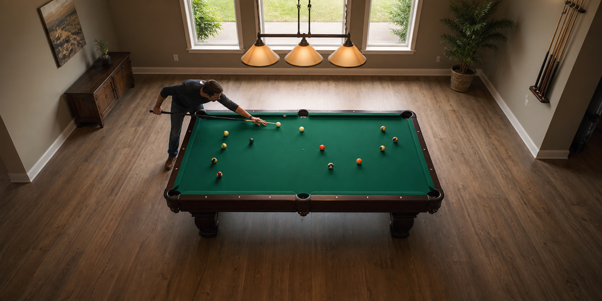 Player testing cue clearance around a full-size pool table in a spacious games room